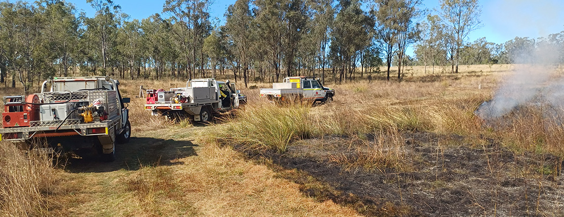 Vehicles at burn in paddock