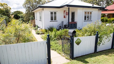 House with fence and garden with native plants
