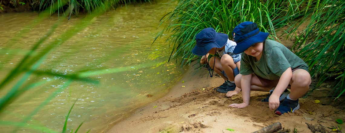 Two boys next to creek