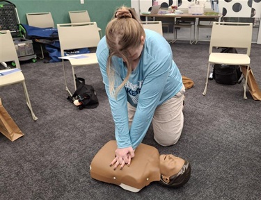 Adult practicing CPR on mannequin 