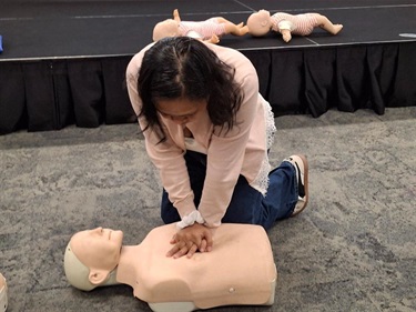Adult practicing CPR on mannequin 