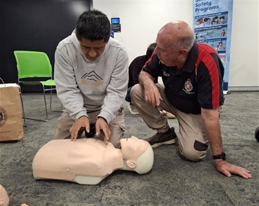 Instructor and Adult practicing CPR on mannequin 